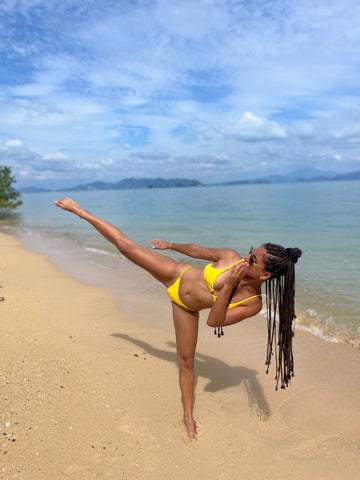 Fille qui met un higk kick à la plage
