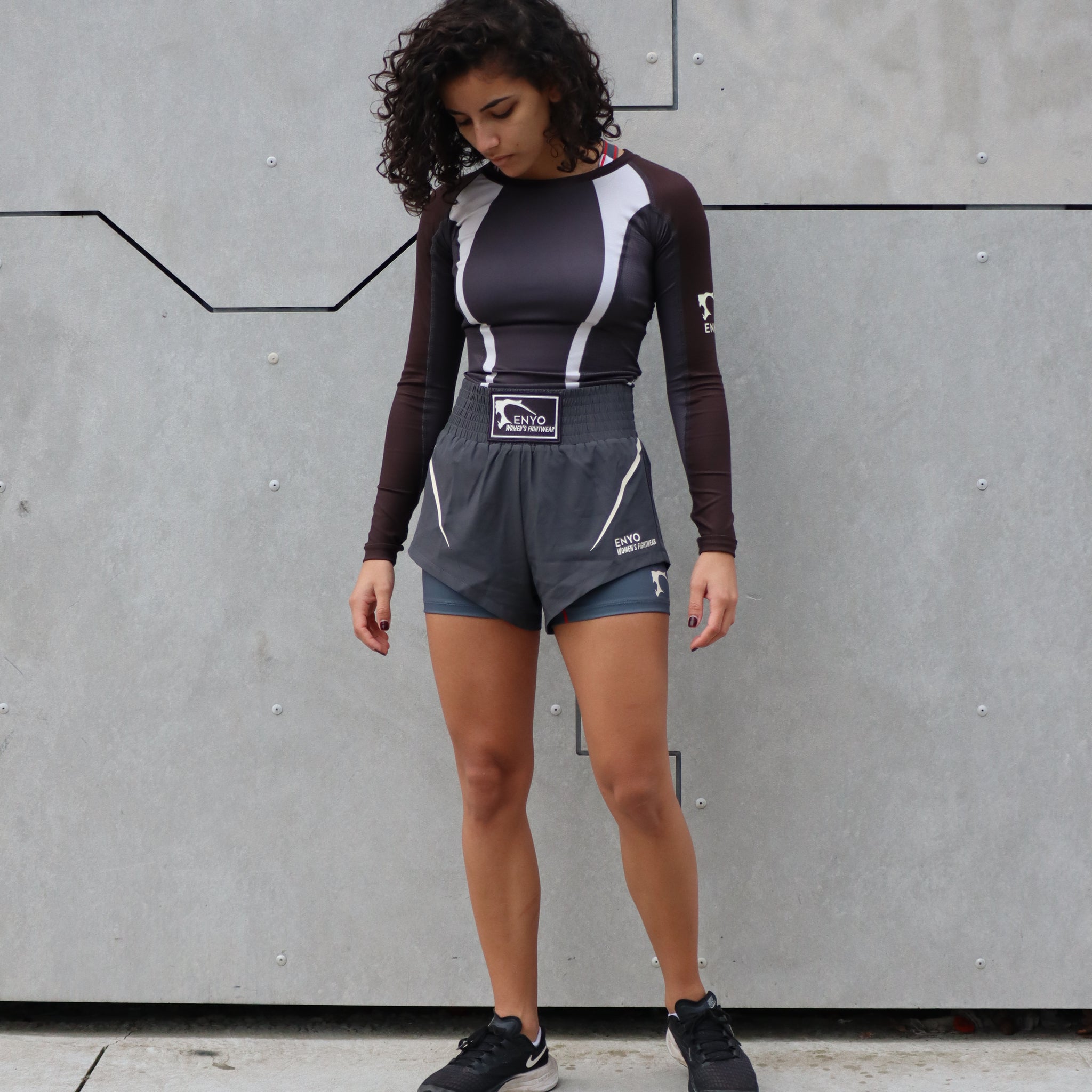 Femme en tenue de sport de combat, rashguard manches longues et short