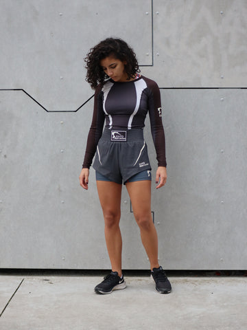 Femme en tenue de sport de combat, rashguard manches longues et short